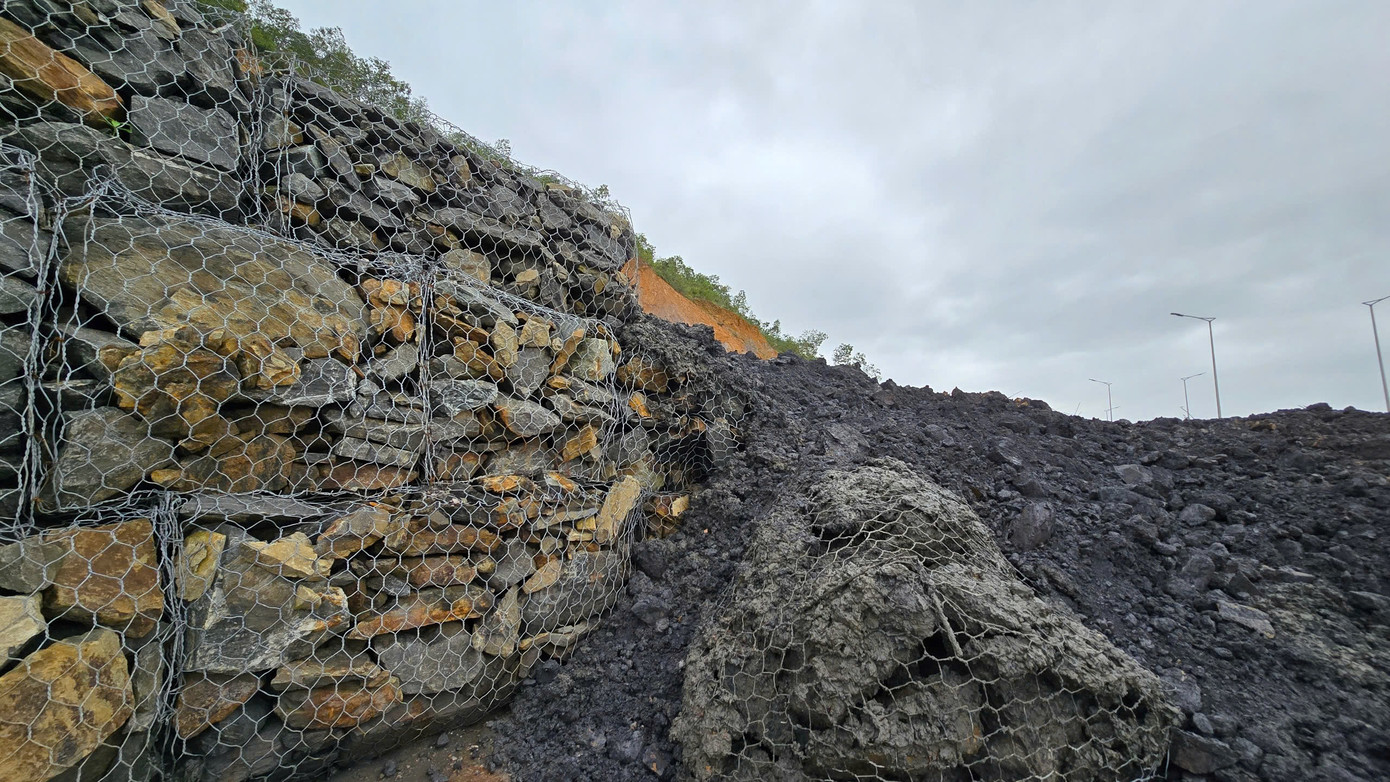 Các rọ đá bị đất đá từ trên núi cao xô ngã, tràn xuống mặt đường.