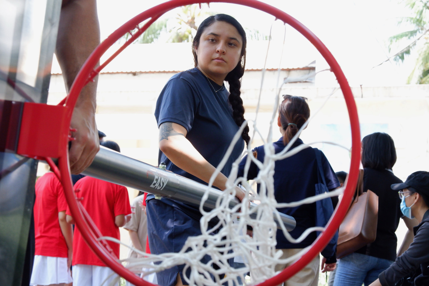 Nữ thủy thủ cùng đồng nghiệp lắp đặt sân bóng rổ tặng trẻ em Làng Hy vọng. Ảnh: Nguyễn Thành