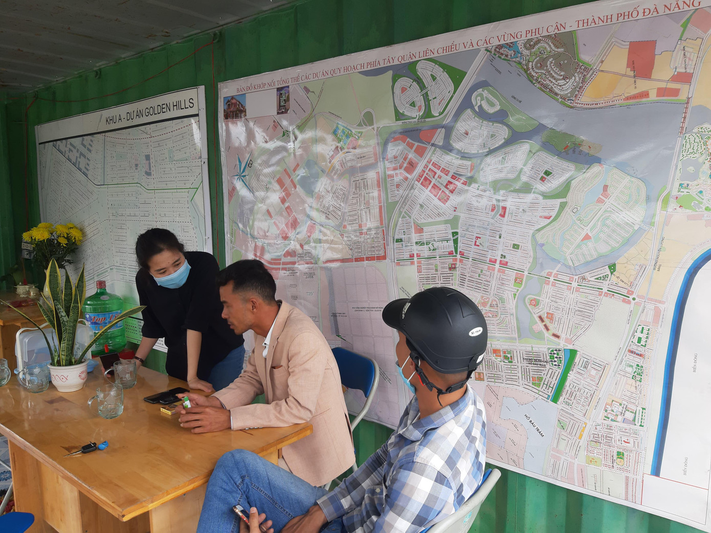 Khách hàng tìm hiểu giá đất bên trong một ki - ốt trên đường Nguyễn Tất Thành (nối dài). Để chào mời khách mua, những “cò” đất tại đây khi được hỏi đều dùng lời lẽ phân tích, lôi kéo người mua nên đầu tư vào đây vì Cảng Liên Chiểu đã được Thủ tướng phê duyệt, dự án Làng Vân khởi động lại, toàn bộ khu vực phía tây thành phố sẽ rất tiềm năng.