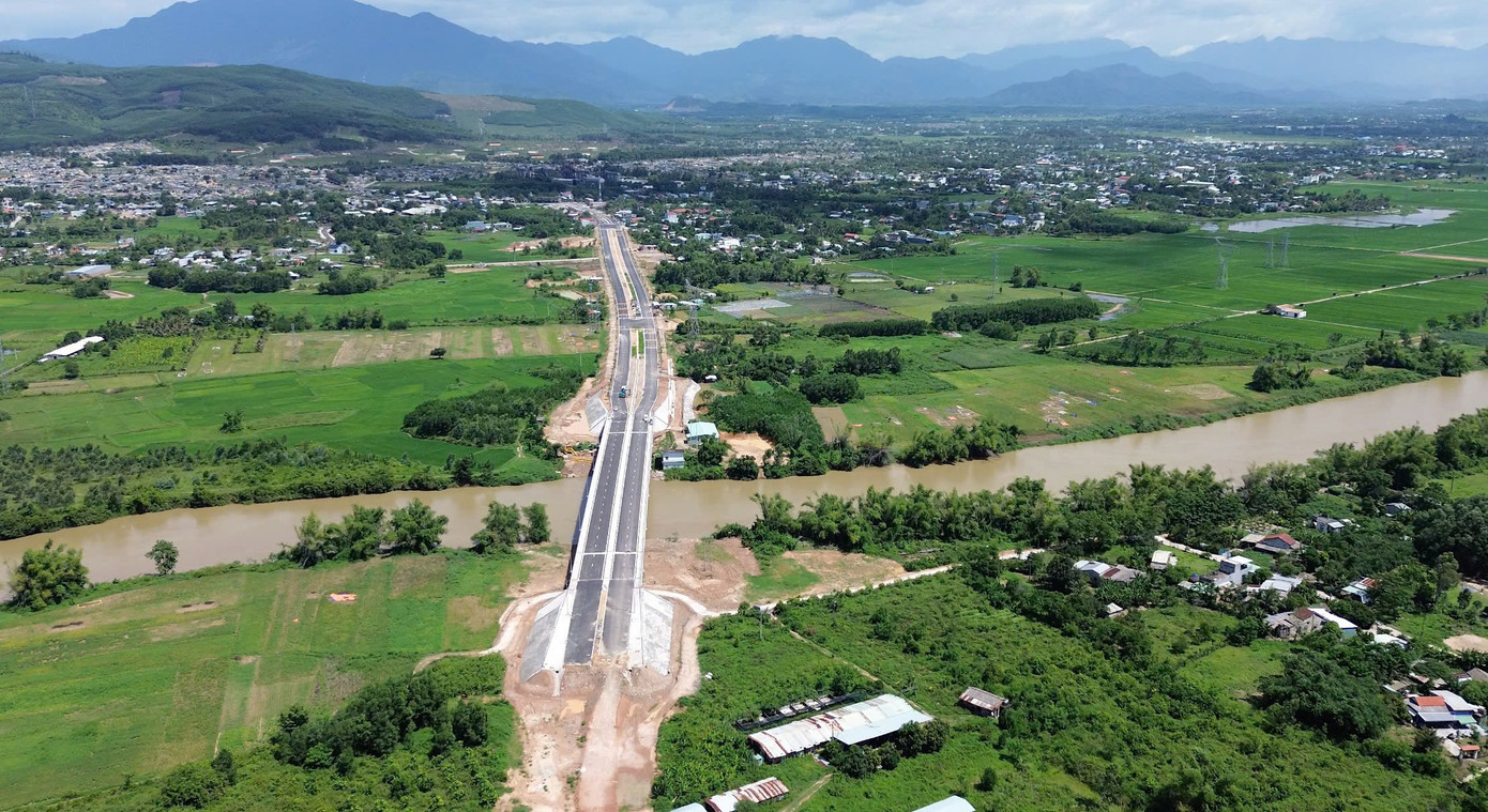 Cầu Quảng Đà nhìn từ trên cao, phần đường dẫn phía xã Hòa Tiến đã hoàn thành và đấu nối vào QL 14B. Trong khi bên này sông ở phía phường Điện Bàn Bắc tất cả vẫn đang còn dang dở.