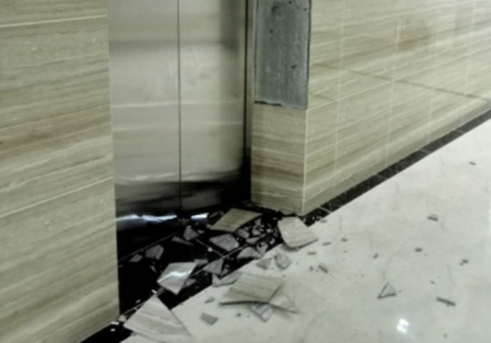 Hình ảnh gạch ốp tường bong, vỡ vụn tại thang máy của chung cư.