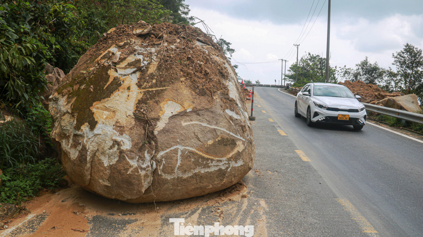 Một tảng đá lớn lăn từ núi xuống nằm giữa đường lên đèo Hải Vân gây cản trở, ảnh hưởng đến giao thông đi lại trên đèo. Ảnh: Nguyễn Thành.