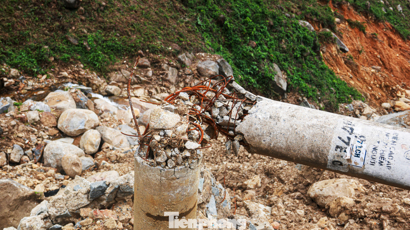 Một trụ điện bị đất đá xô gãy trơ sắt thép tại một điểm sạt lở. Ảnh: Nguyễn Thành.