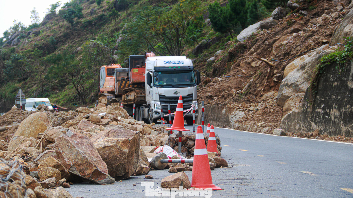 Một khối lượng đất đá lớn đổ từ trên núi cao xuống đường lên đỉnh đèo Hải Vân, xe cộ di chuyển khó khăn. Ảnh: Nguyễn Thành.
