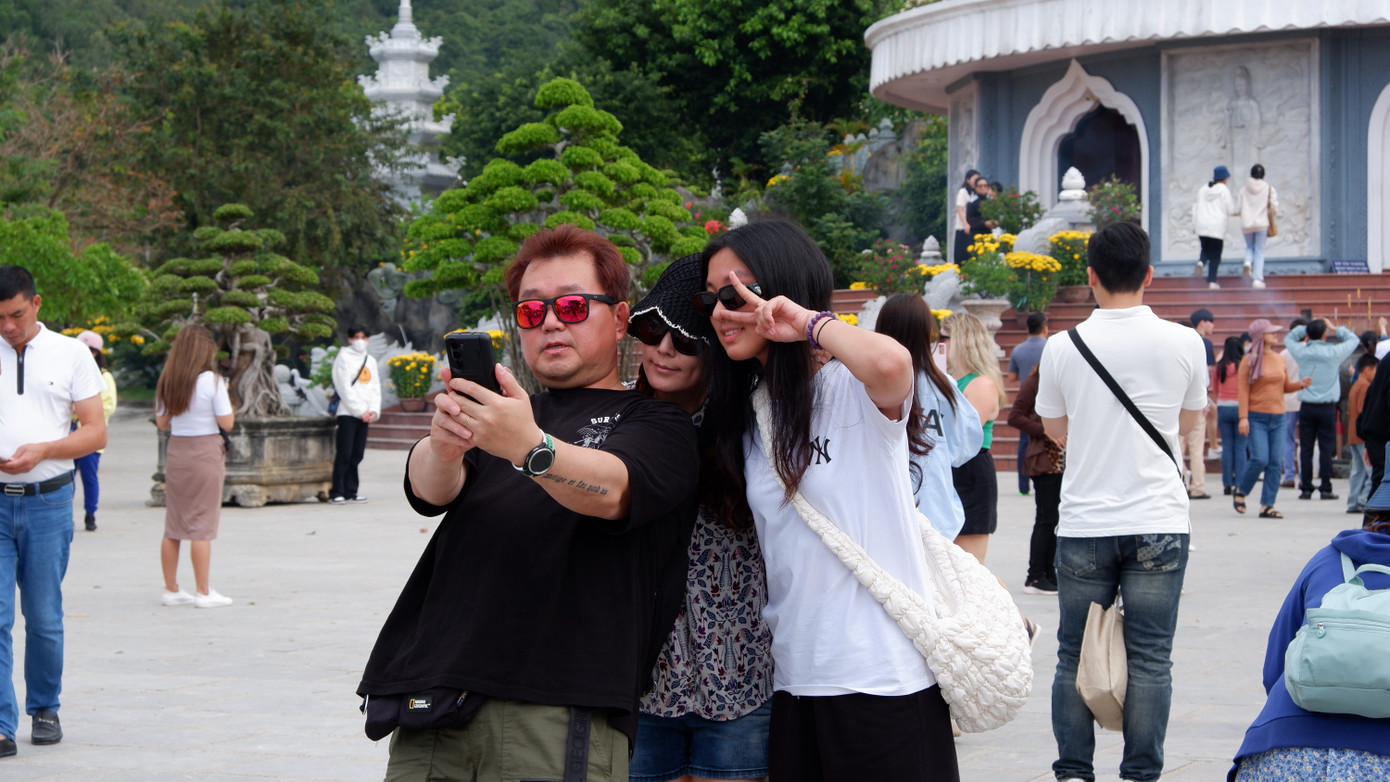 Một gia đình lưu lại khoảnh khắc kỷ niệm bên tượng Phật Quan Âm khi đến chùa Linh Ứng .