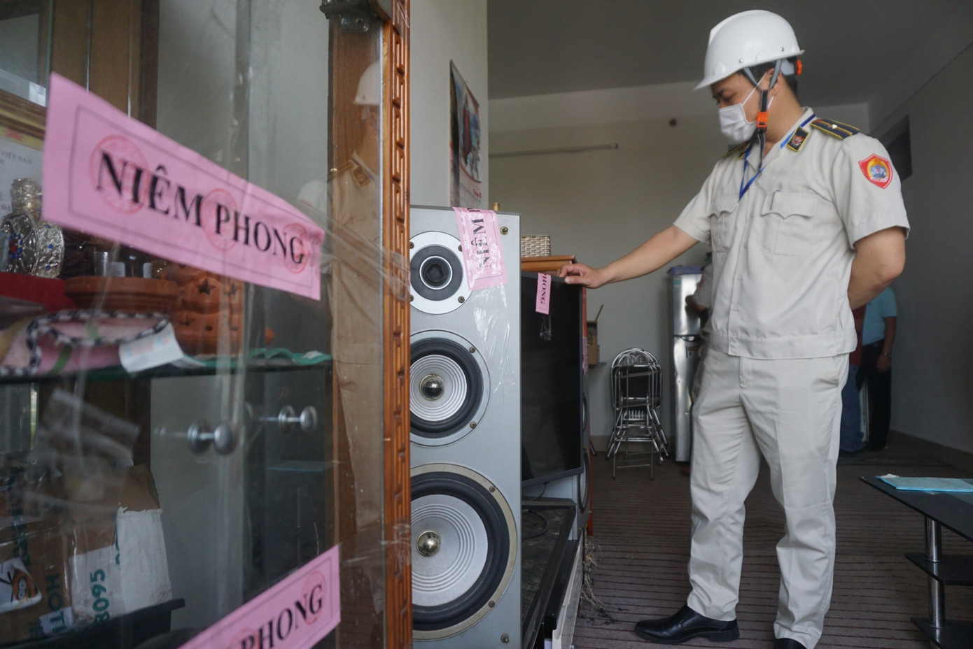 Lực lượng chức năng tiến hành lập biên bản, tiến hành niêm phong các tài sản của người dân trong các căn hộ chung cư.