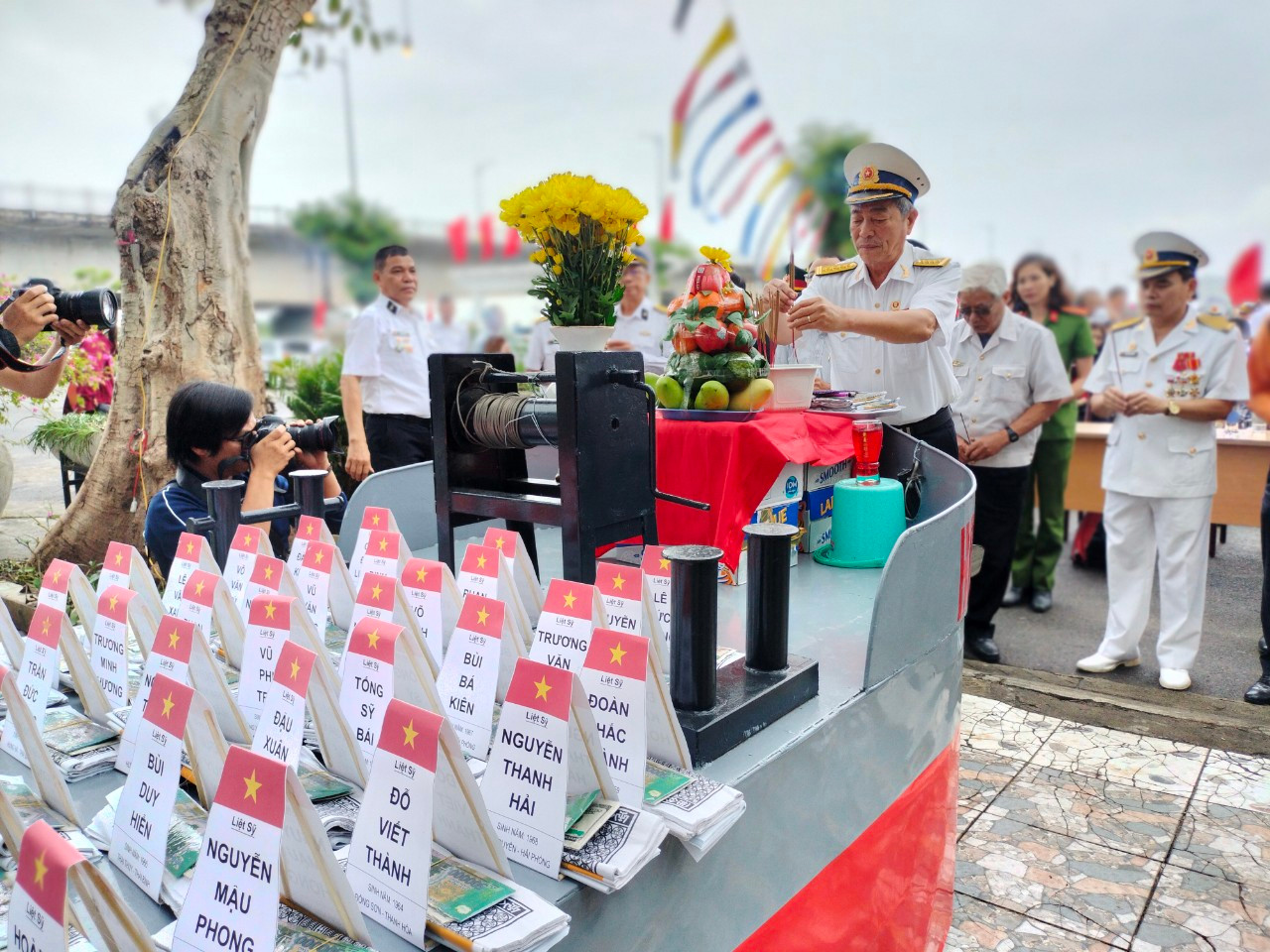 Bài vị 64 liệt sĩ Gạc Ma được đặt trên mô hình tàu HQ604, mọi người cùng lần lượt thắp hương tưởng nhớ.