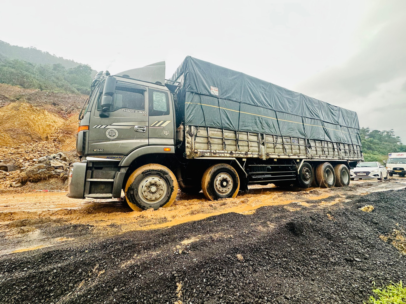 Tại vị trí này, một phần khối núi ở taluy bị sạt xuống. Hàng ngàn mét khối đất đá tràn ra mặt đường. Tại vị trí này, một phần khối núi ở taluy bị sạt xuống. Hàng ngàn mét khối đất đá tràn ra mặt đường.