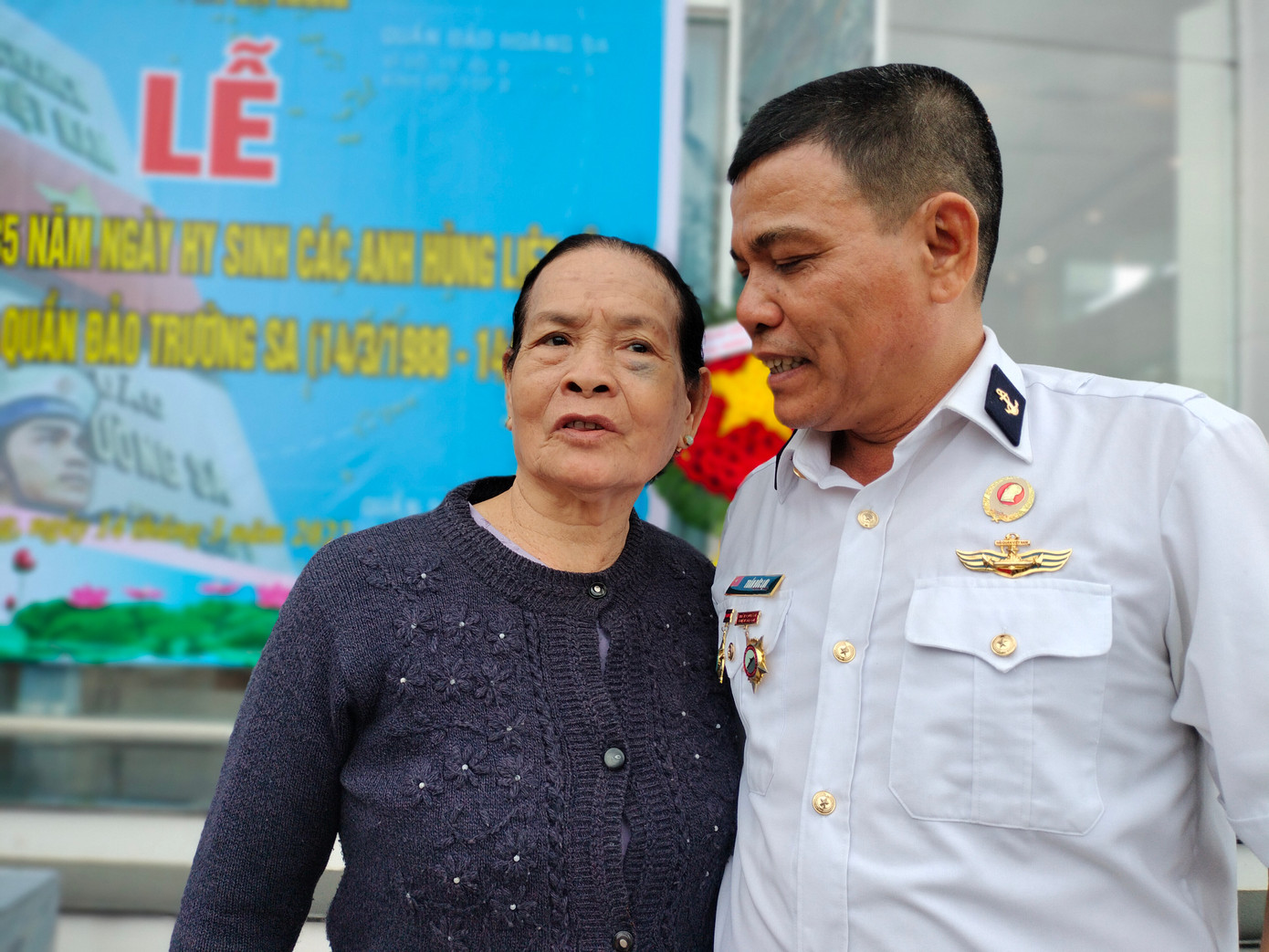 Anh Trần Đức Lợi (đồng đội của Liệt sĩ Lê Thế) thăm hỏi mẹ Huệ tại lễ tưởng niệm.