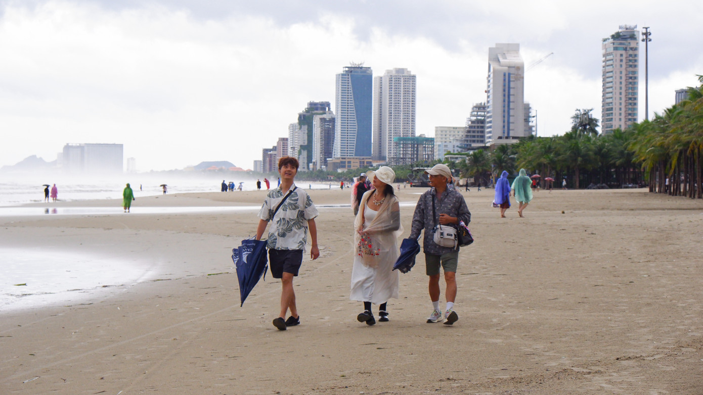 Nước biển dâng cao trong khi bão vào đã làm bãi biển bằng phẳng lại. Sau bão, du khách thích thú dạo trên bãi cát mịn ở biển Đà Nẵng.