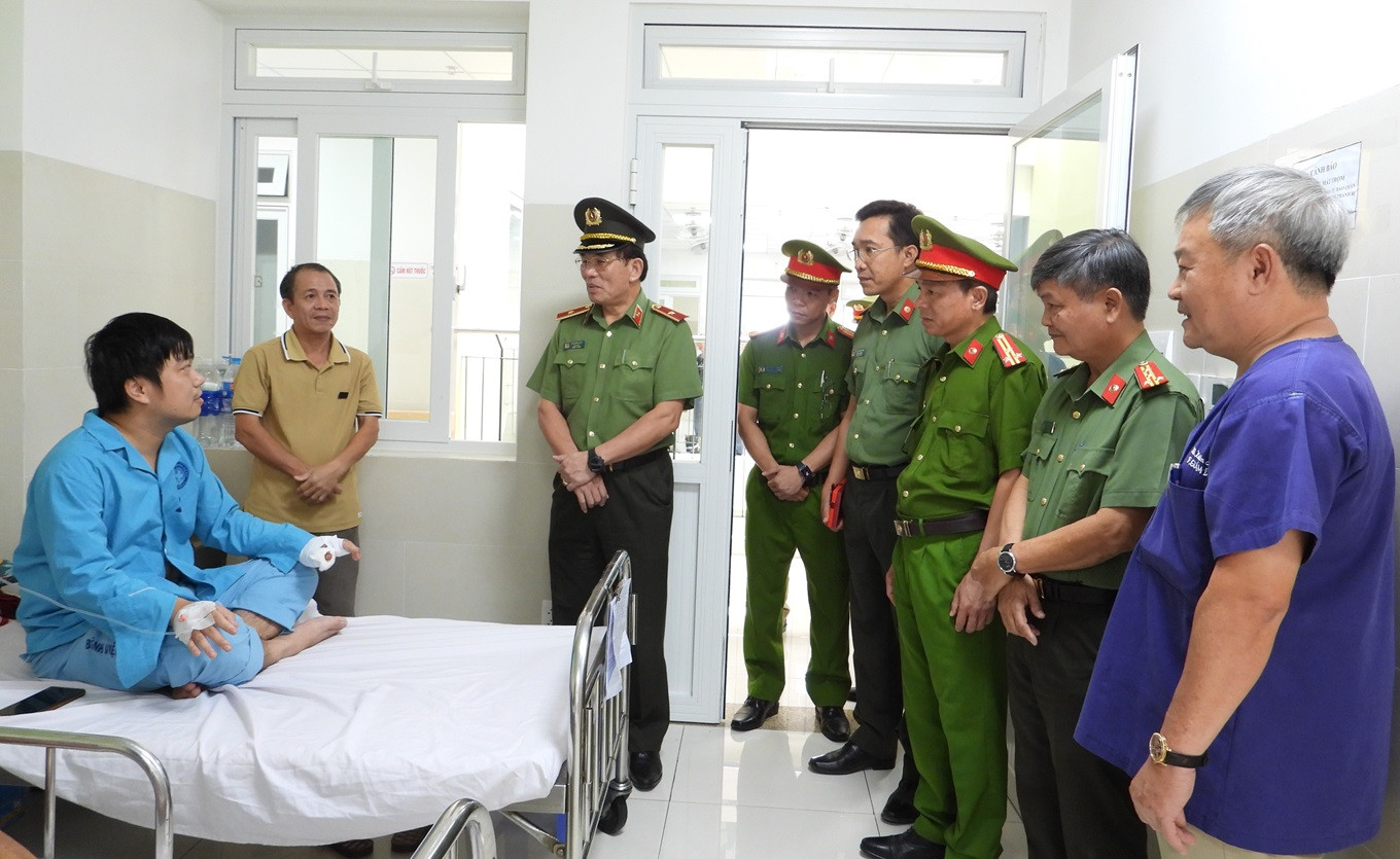 Thiếu tướng Vũ Xuân Viên - Giám đốc Công an TP. Đà Nẵng và lãnh đạo Công an TP thăm hỏi động viên 2 cán bộ, chiến sĩ bị thương. Ảnh: Doãn Hùng.