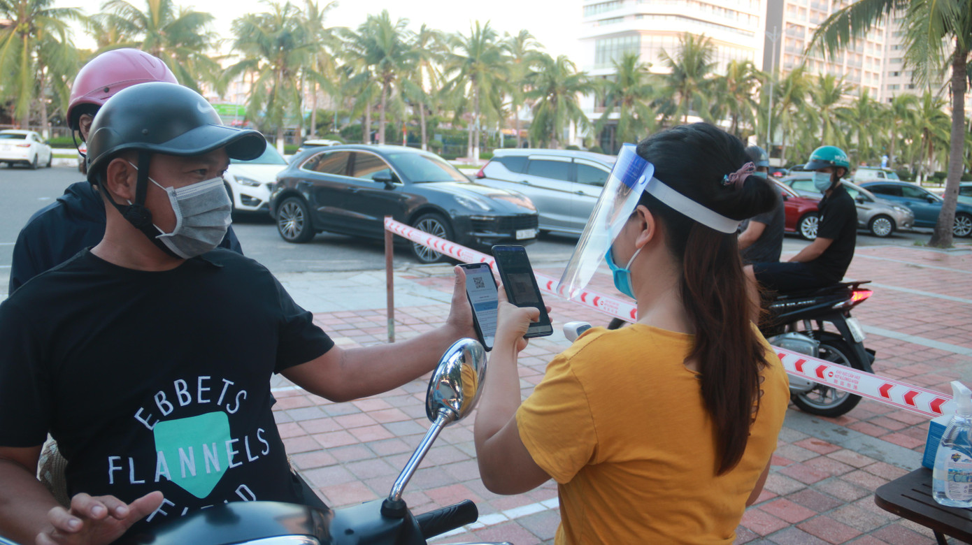 Để được vào các bãi tắm, người dân được đo thân nhiệt và quét mã QR theo quy định của TP.