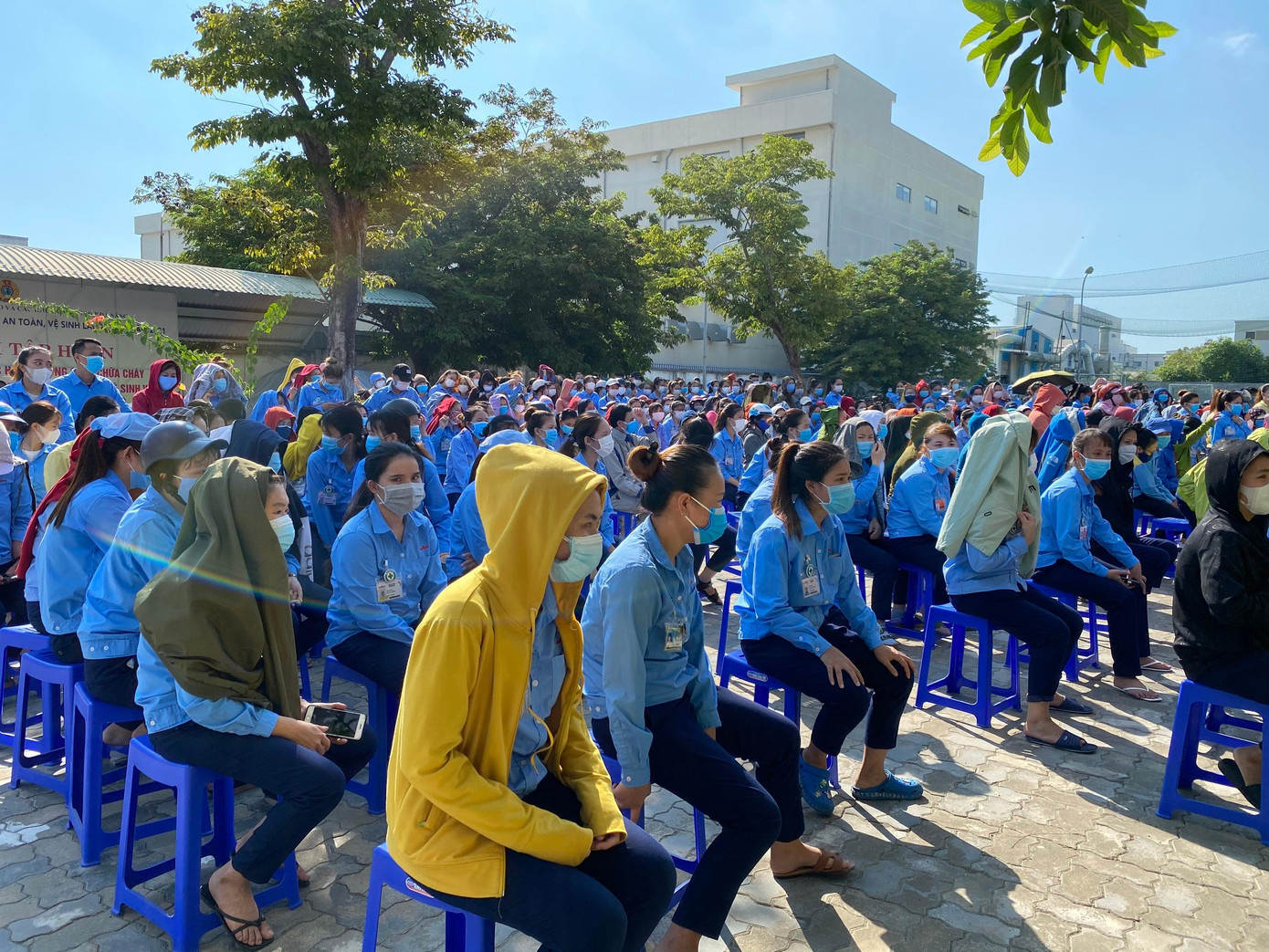 Các công nhân đội nắng, ngồi chờ đến lượt lấy mẫu xét nghiệm tại Trung tâm Văn hóa Thể thao Công nhân - đường số 2 - KCN Hòa Khánh.