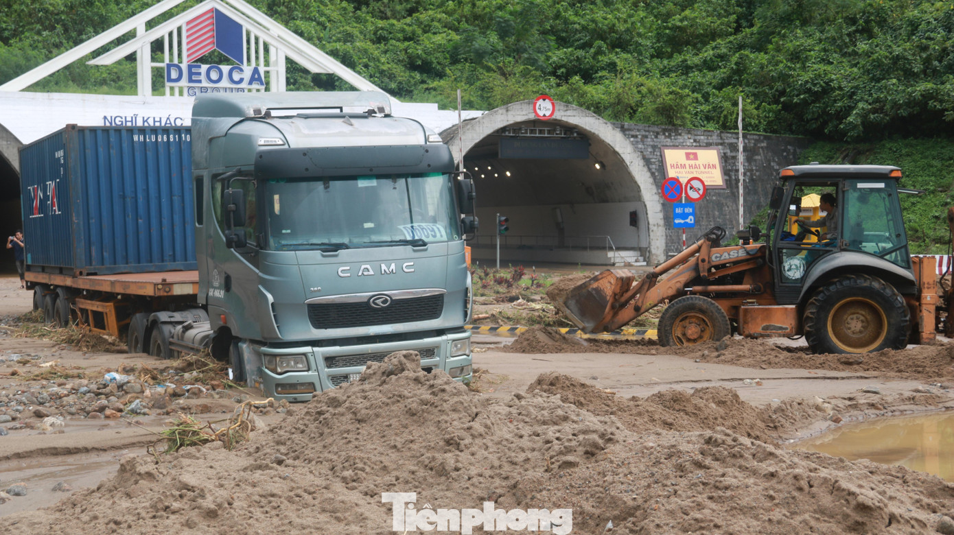 Một xe tải lớn mắc kẹt trong đất đá chưa thể di chuyển khỏi điểm sạt lở. Ảnh: Nguyễn Thành