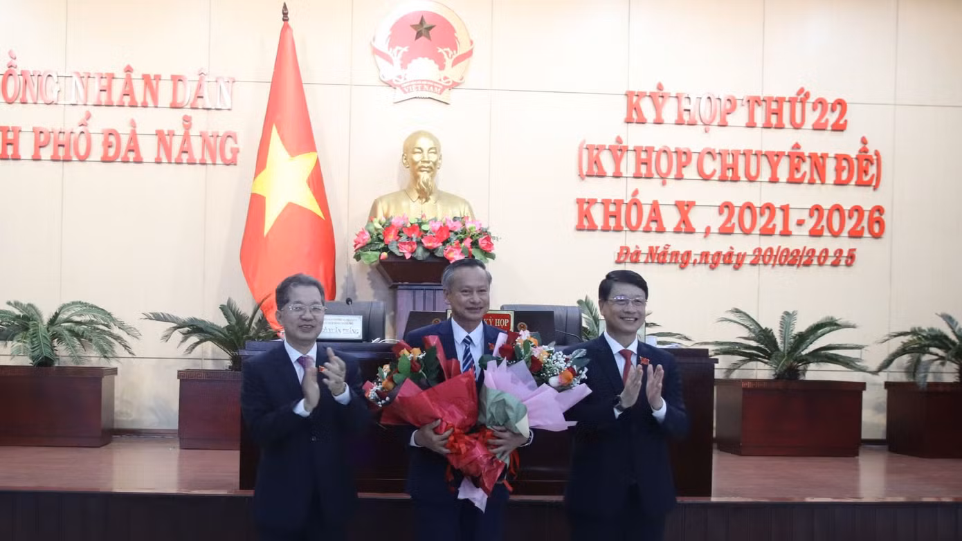 Ông Đoàn Ngọc Hùng Anh (giữa) nhận hoa chúc mừng của lãnh đạo thành phố.