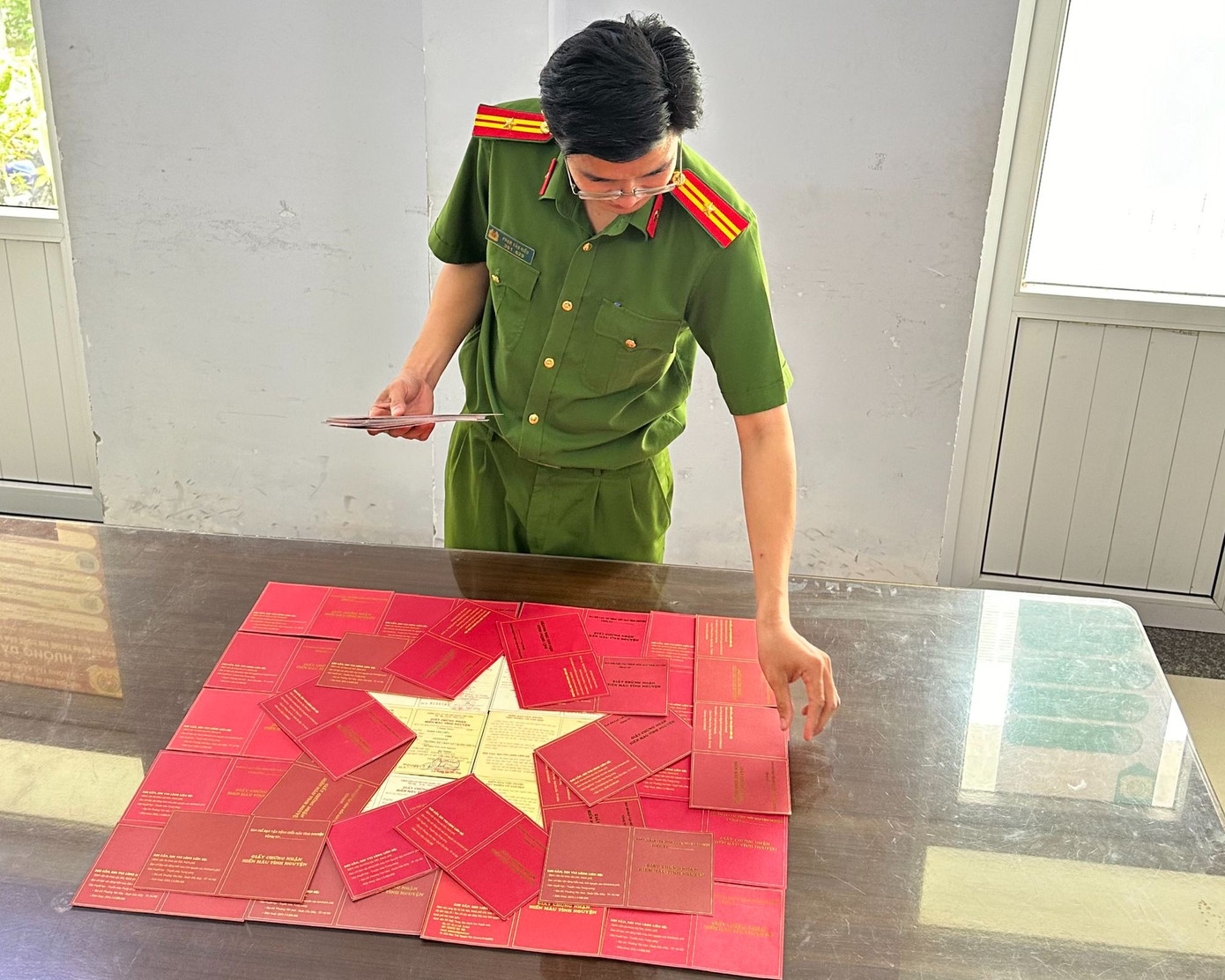 Thiếu tá Phạm Văn Hiếu ghép cờ Tổ quốc từ các giấy chứng nhận hiến máu cứu người. Thiếu tá Phạm Văn Hiếu ghép cờ Tổ quốc từ các giấy chứng nhận hiến máu cứu người.