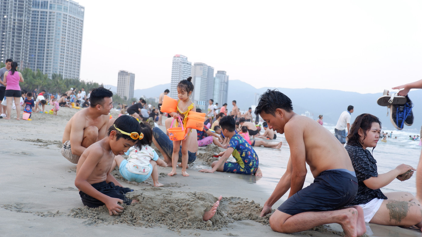 Các gia đình, trẻ nhỏ cùng vui chơi trên bãi biển sạch mịn.