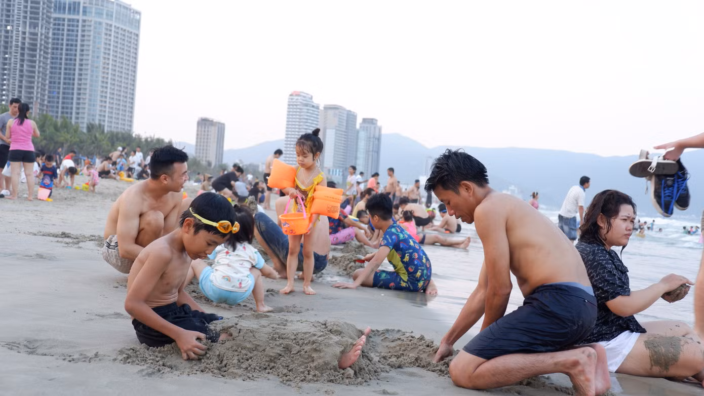 Các gia đình, trẻ nhỏ cùng vui chơi trên bãi biển sạch mịn.