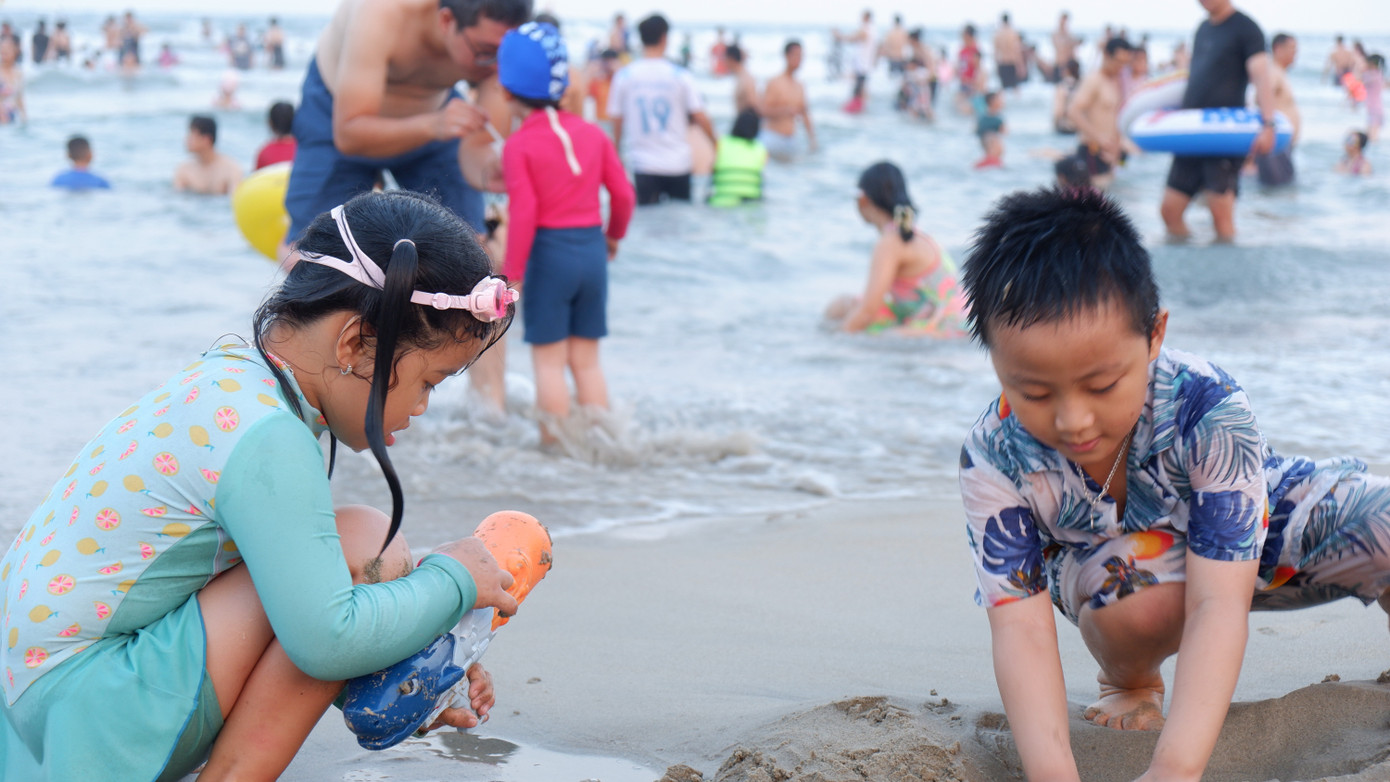 Các gia đình, trẻ nhỏ cùng vui chơi trên bãi biển sạch mịn.