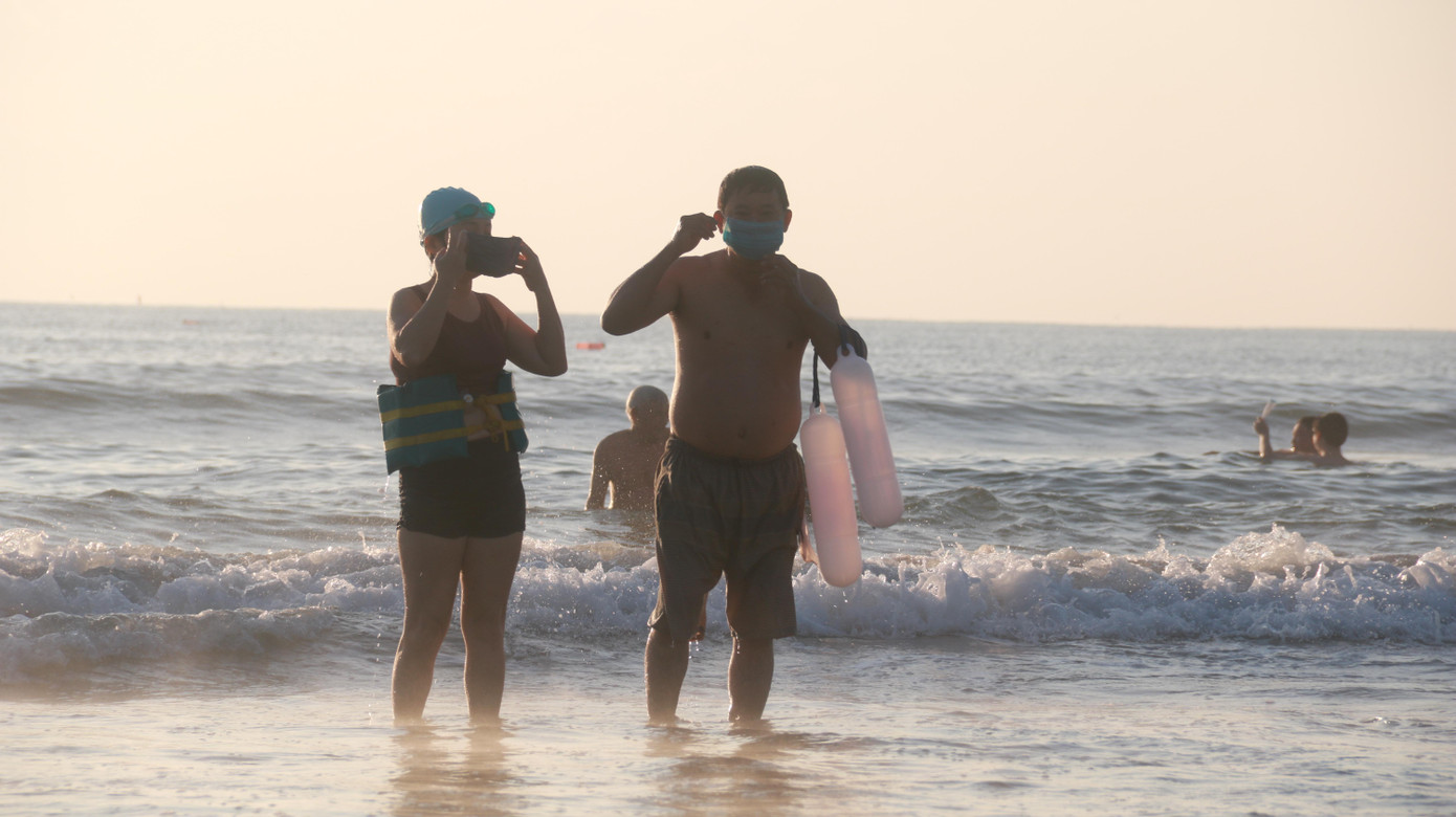 Người dân Đà Nẵng chấp hành nghiêm việc đeo khẩu trang sau khi tắm xong.