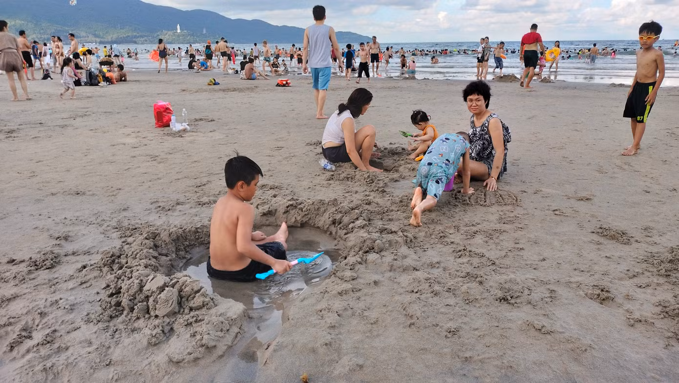 Các em nhỏ và gia đình thỏa thích nghịch cát trên bãi biển Mỹ Khê. Các em nhỏ và gia đình thỏa thích nghịch cát trên bãi biển Mỹ Khê.