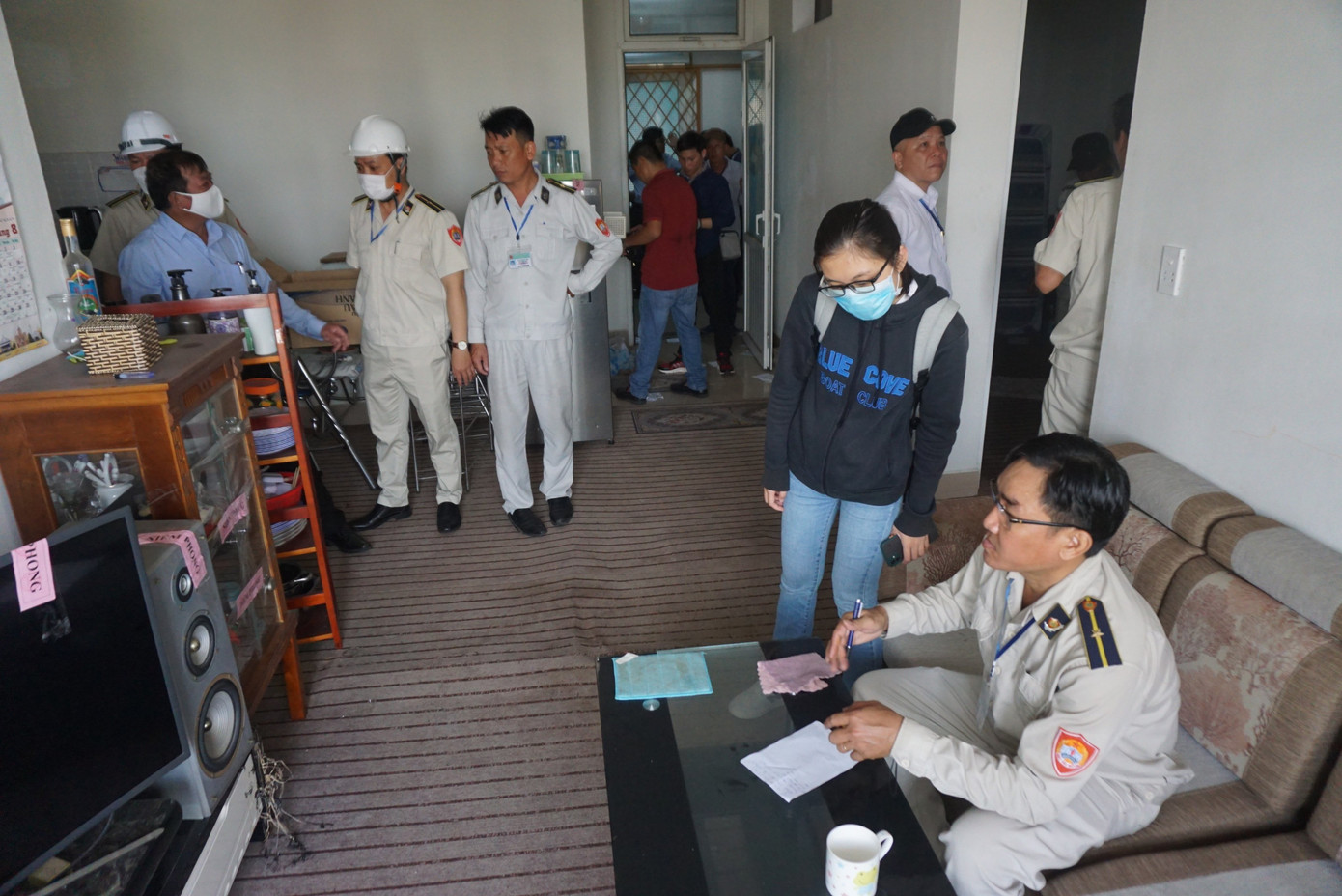 Lực lượng chức năng tiến hành lập biên bản, tiến hành niêm phong các tài sản của người dân trong các căn hộ chung cư.