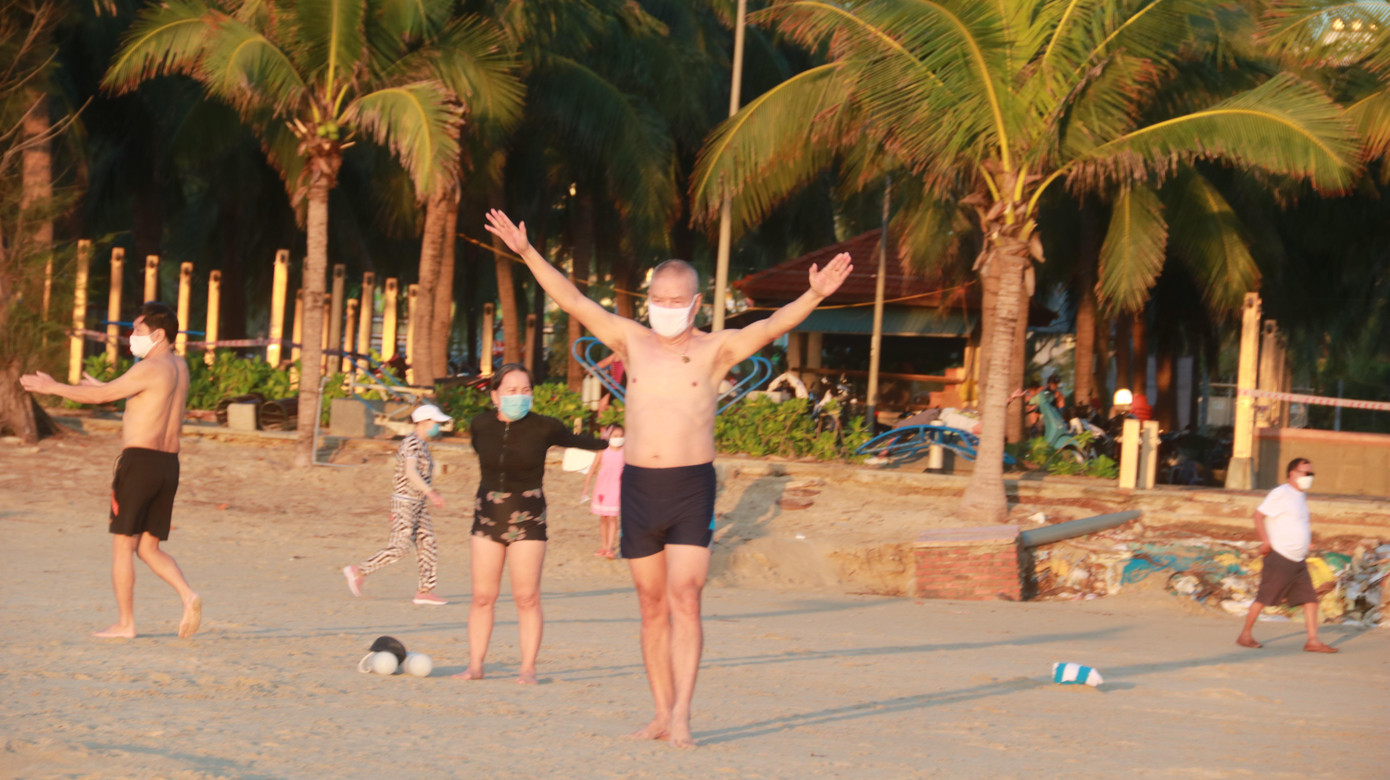 Người dân đeo khẩu trang, chấp hành việc giữ khoảng cách khi tập thể dục trên bãi biển.