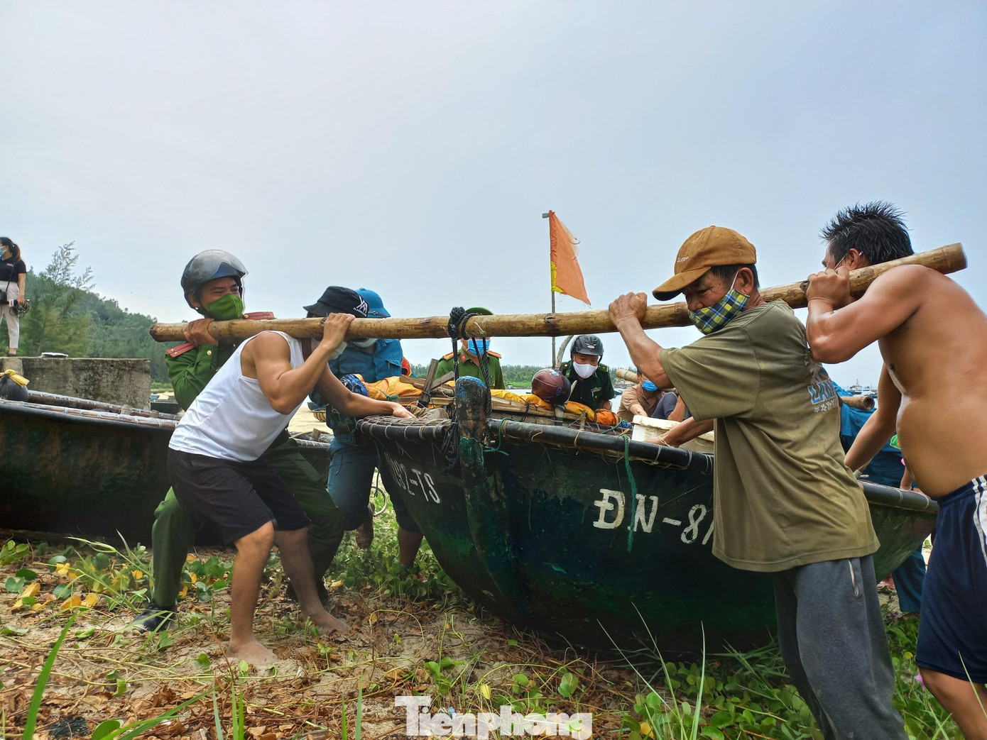 Mọi người cùng chung sức, hô hào nhau kéo tàu thuyền lên bờ.