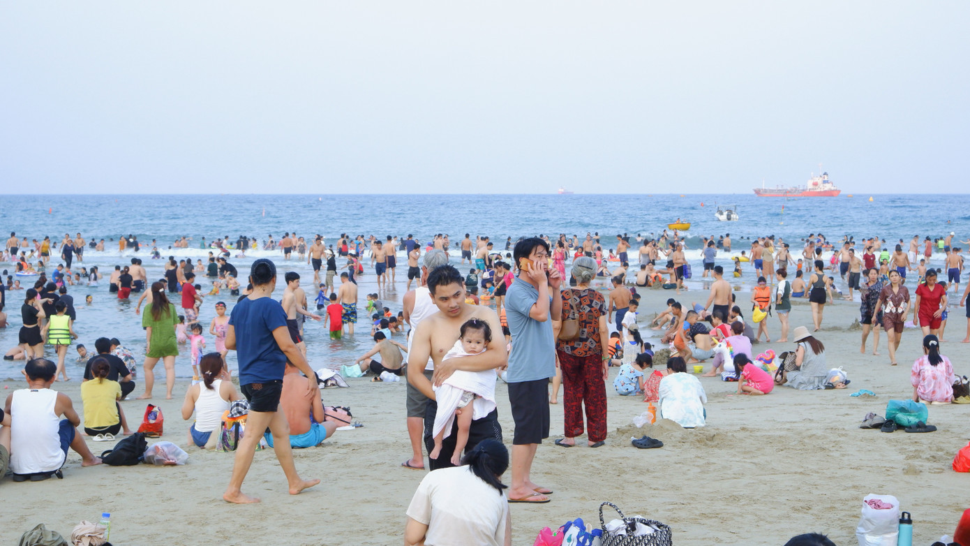 Nắng nóng, khiến người dân đổ xô về các bãi tắm Đà Nẵng để nghỉ ngơi, tắm mát, giải nhiệt tăng cao.