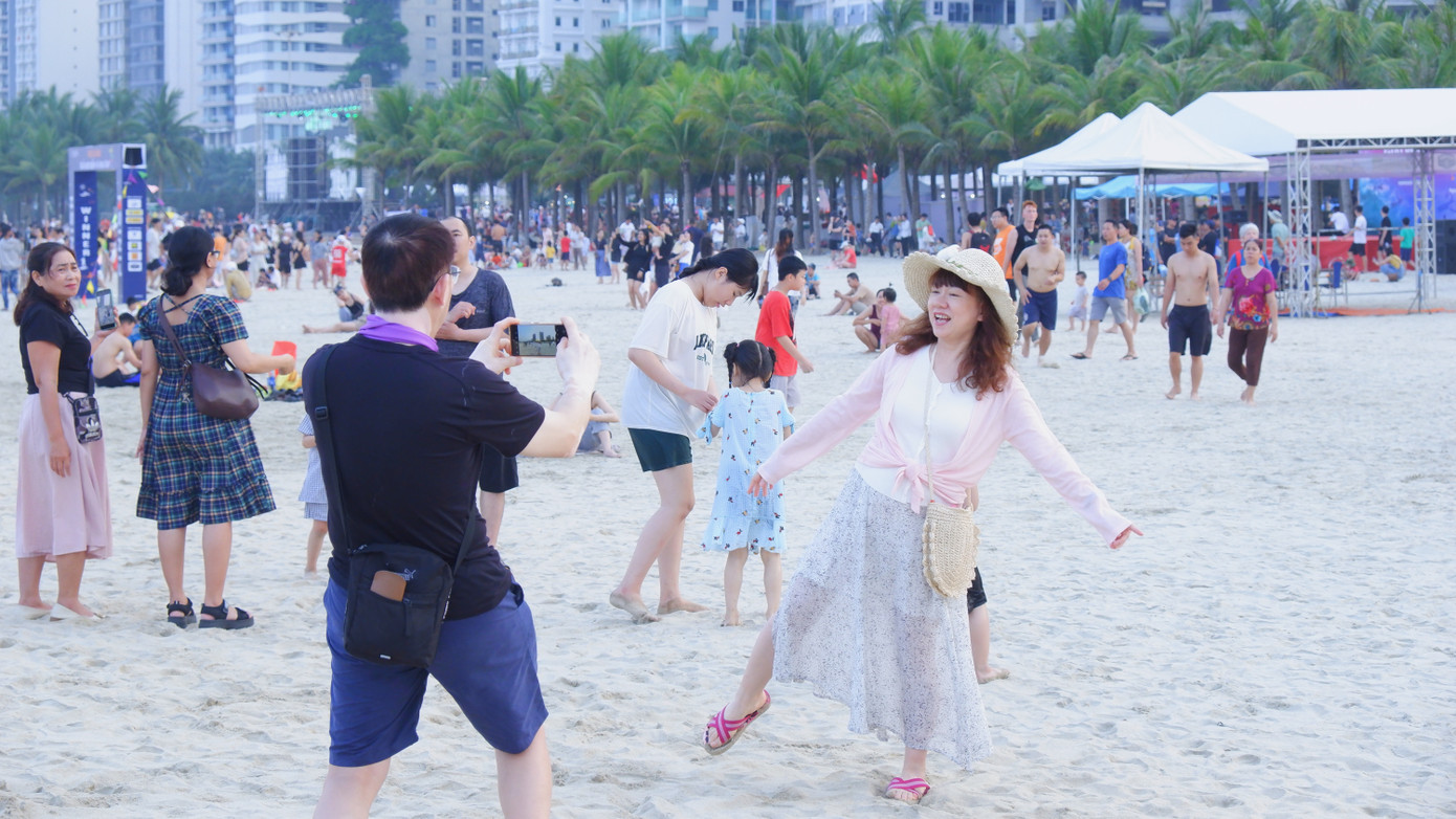 Một cặp đôi du khách Hàn Quốc thỏa thích tạo dáng, check-in trên bãi biển Đà Nẵng.