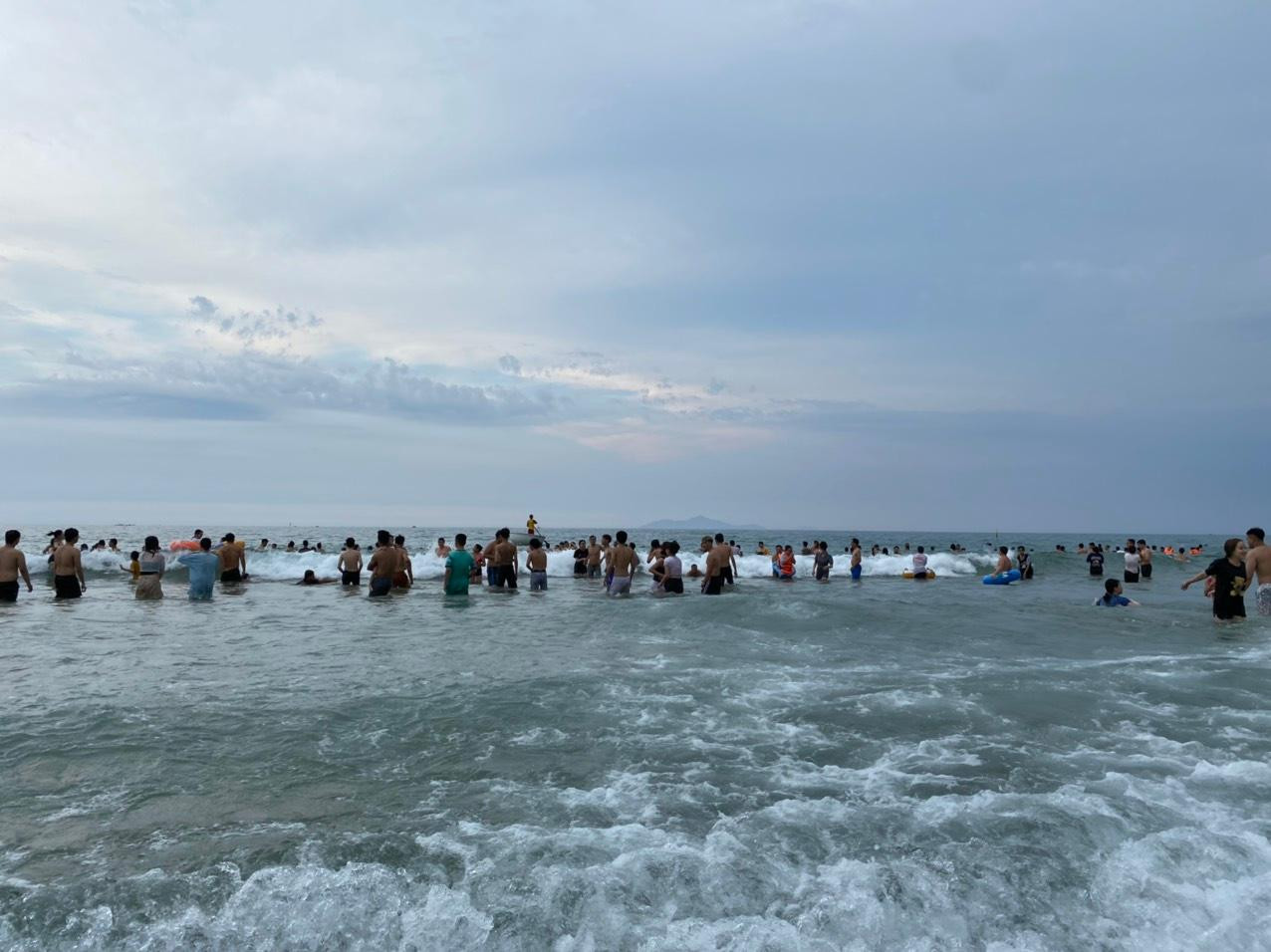 Dưới biển, hàng ngàn người ngâm mình trong làn nước mát.