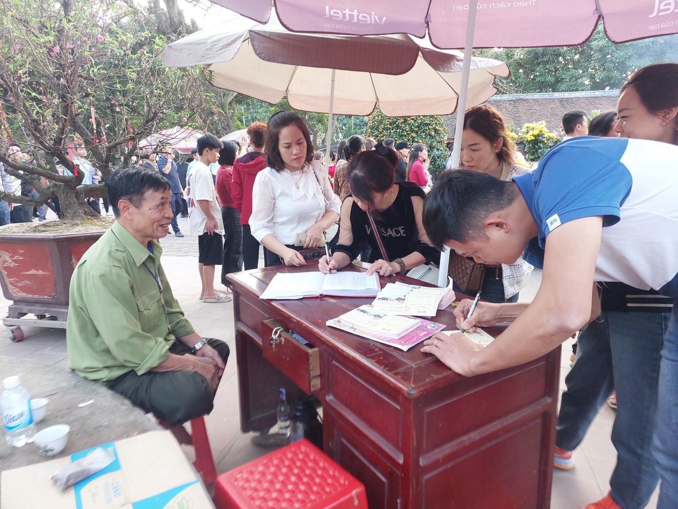 Người dân ghi phiếu công đức tại Đền Trần - Nam Định. (Ảnh: QN).