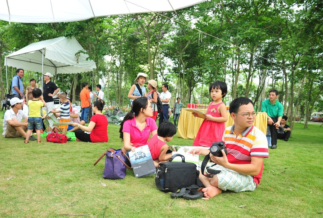 Nhiều gia đình đến trễ, không còn ghế đã ngồi bệt xuống cỏ xanh để thưởng thức âm nhạc