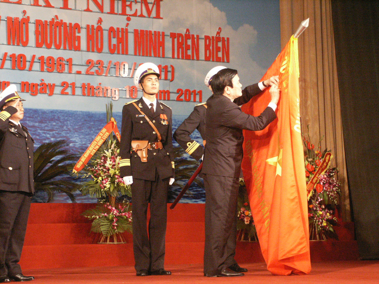 Chủ tịch nước gắn Huân chương Hồ Chí Minh lên lá cờ truyền thống hải quân Việt Nam.