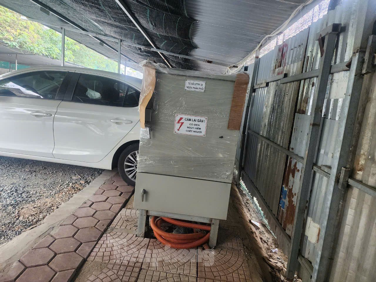 "Tôi không hiểu tại sao bãi xe quây tôn chiếm gọn vỉa hè mà chính quyền địa phương thờ ơ, không xử lý", ông H. một người dân gần đó cho biết (ảnh: Một tủ điện trên vỉa hè nằm gọn trong bãi đỗ xe).
