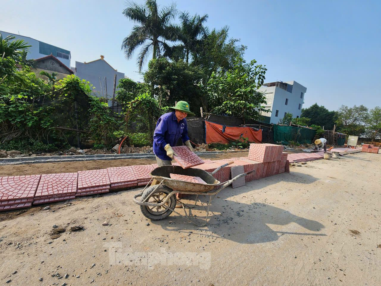 Công nhân vận chuyển gạch lát vỉa hè tại khu đất dịch vụ thuộc xã An Khánh