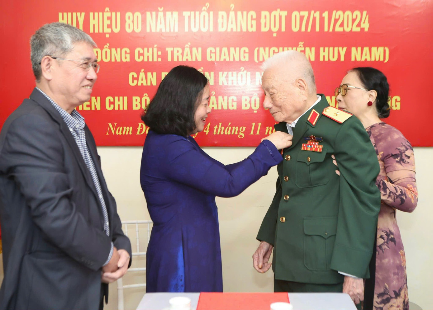 Bí thư Bùi Thị Minh Hoài gắn Huy hiệu 80 năm tuổi Đảng tặng ông Trần Giang.