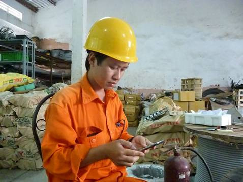 Một công nhân ngành điện đang cài đặt Ca khúc “Tiết Kiệm điện” làm nhạc chờ trên điện thoại di động của mình