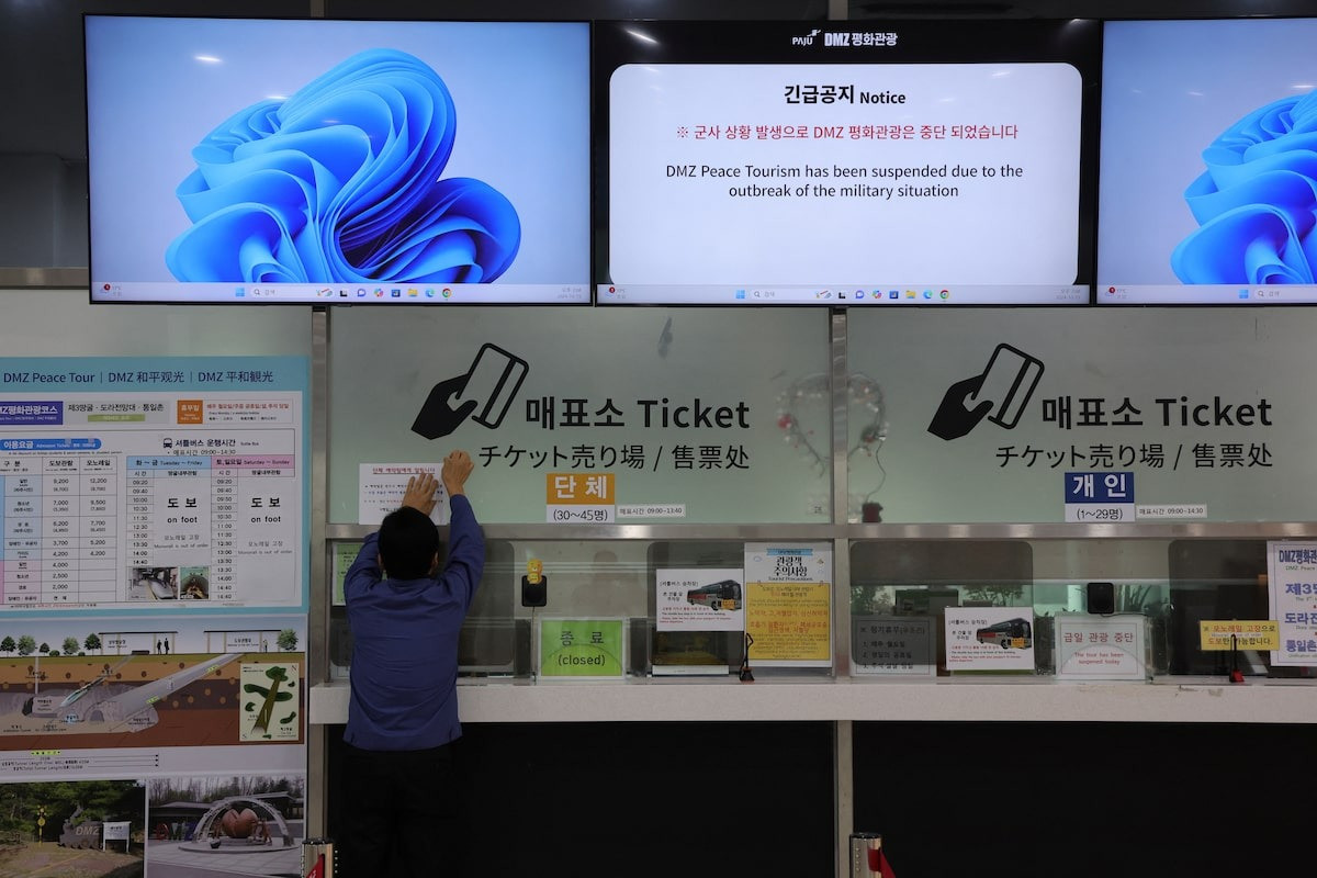 Một người đàn ông dán thông báo tạm dừng chương trình tham quan khu phi quân sự ở Hàn Quốc. (Ảnh: Reuters) Một người đàn ông dán thông báo tạm dừng chương trình tham quan khu phi quân sự ở Hàn Quốc. (Ảnh: Reuters)