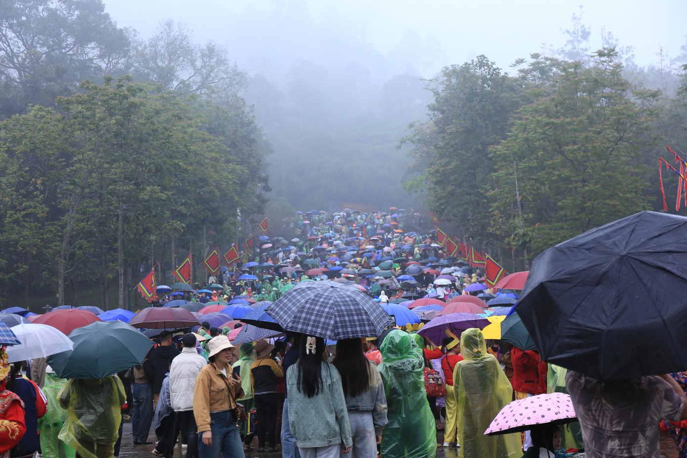 Người dân che ô, khoác áo mưa, bước chậm rãi trên nền đất ẩm ướt, tiến dần lên đỉnh núi Nghĩa Lĩnh để thắp nén hương tưởng nhớ tổ tiên.