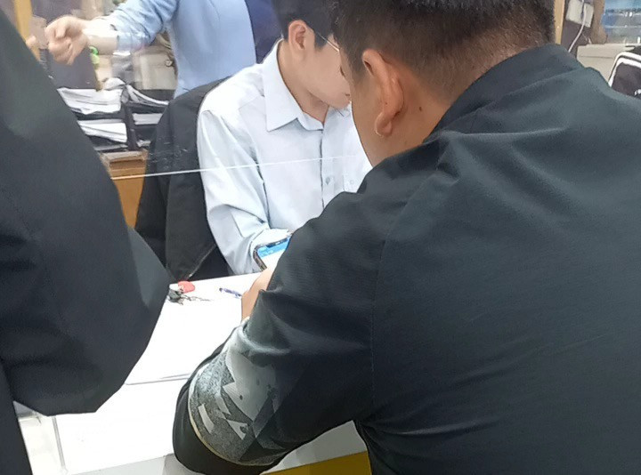 Anh N.Q.H (áo đen bên phải) được nhân viên nhà mạng hướng dẫn thủ tục sang tên và đăng ký gói cước dùng trong 420 ngày.