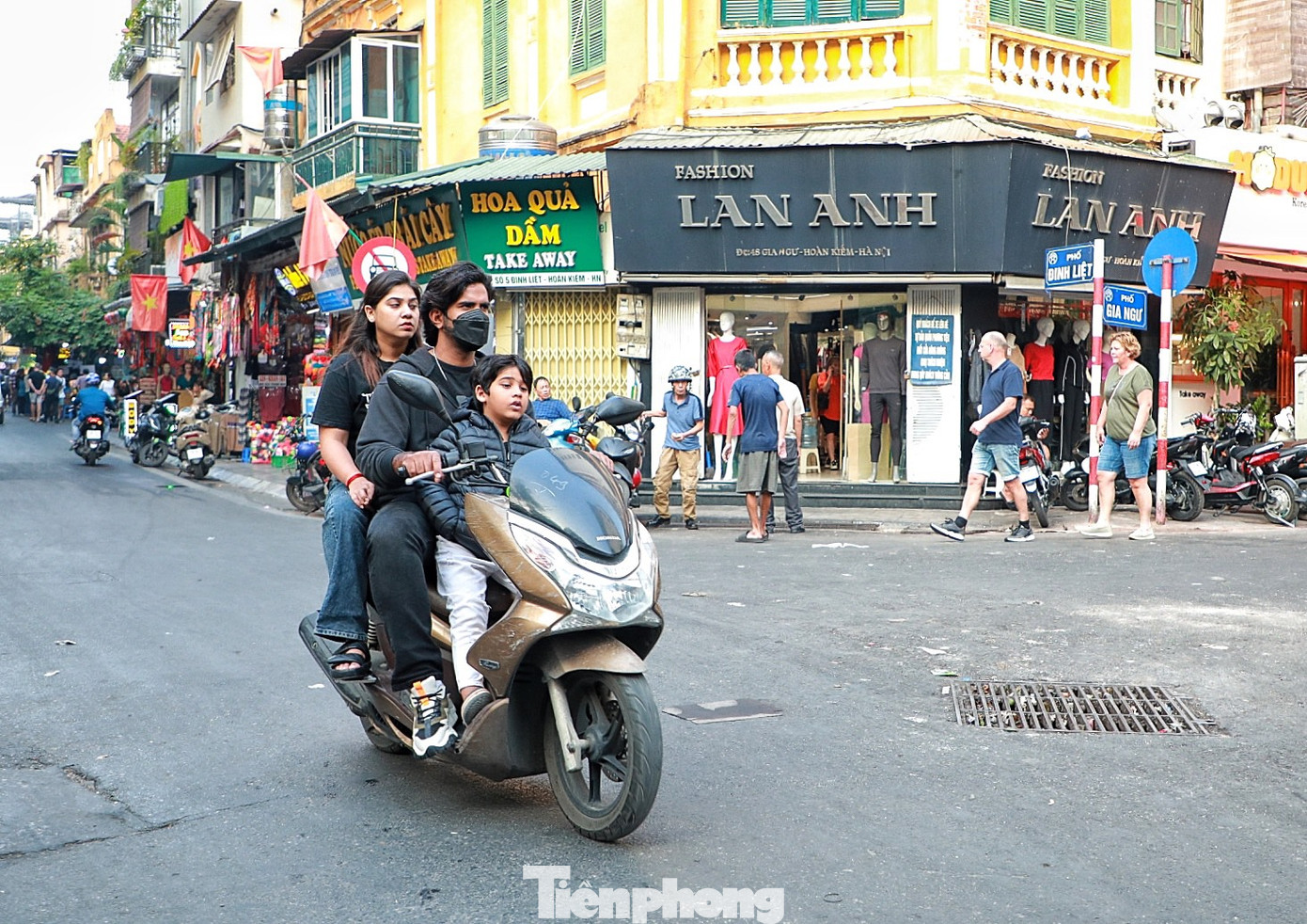 Du khách nước ngoài chở theo trẻ nhỏ vô tư “đầu trần” chạy xe khắp các tuyến đường Hà Nội.