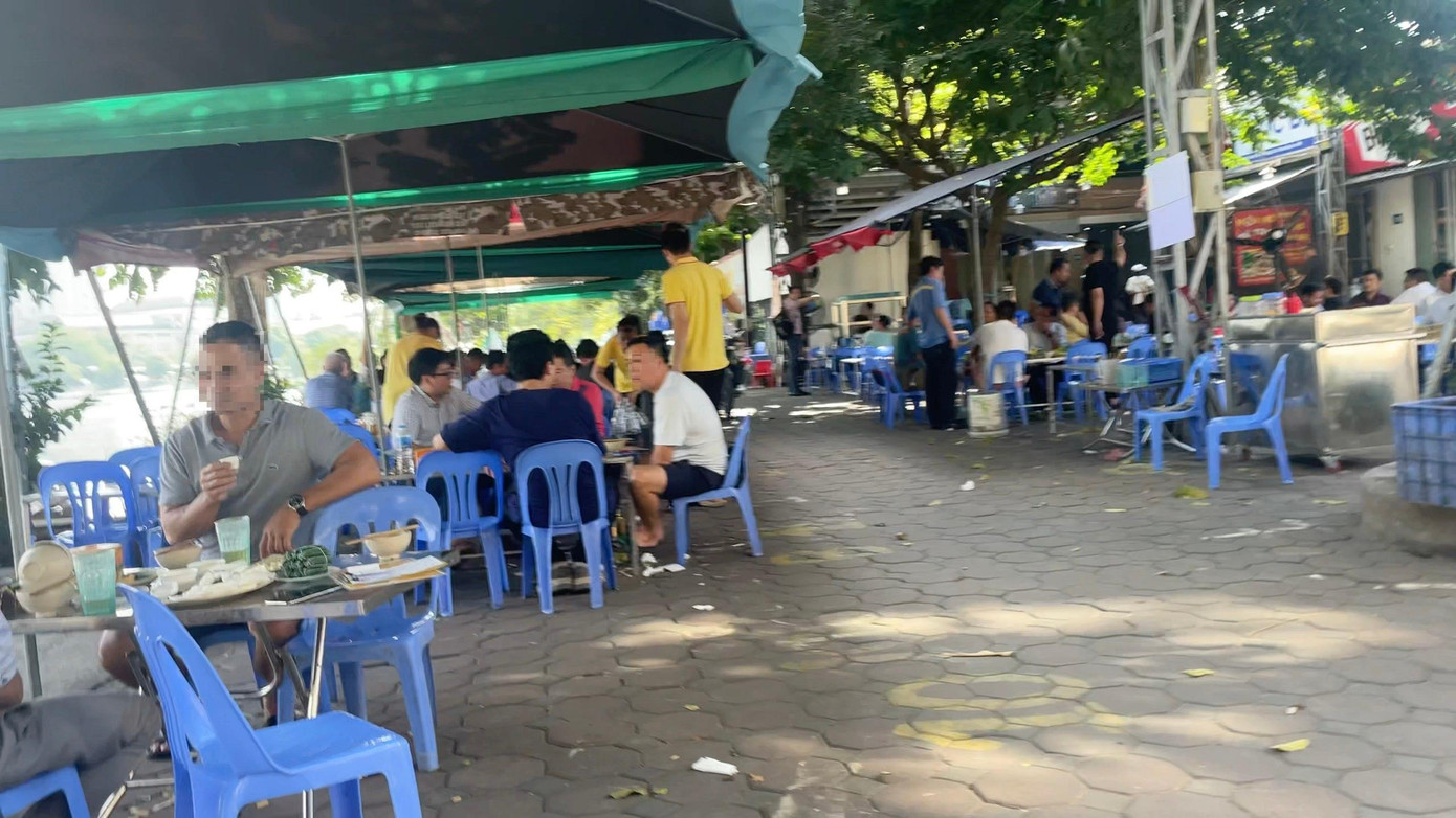Buổi trưa, khu vực hồ Rùa, phường Phương Liệt, quận Thanh Xuân, Hà Nội, một quán bia bày bàn ghế trên mặt đường hồ, trước các nhà dân..