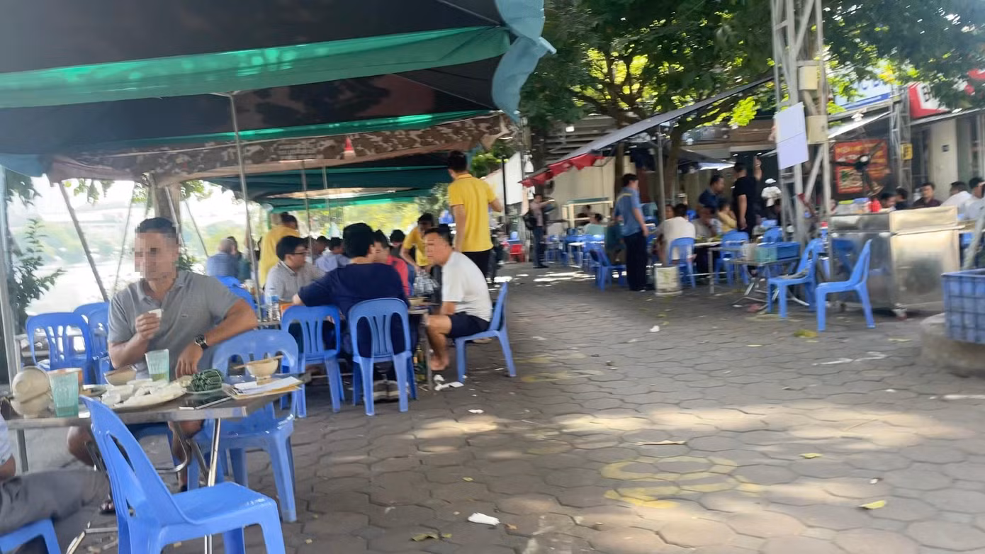 Buổi trưa, khu vực hồ Rùa, phường Phương Liệt, quận Thanh Xuân, Hà Nội, một quán bia bày bàn ghế trên mặt đường hồ, trước các nhà dân..
