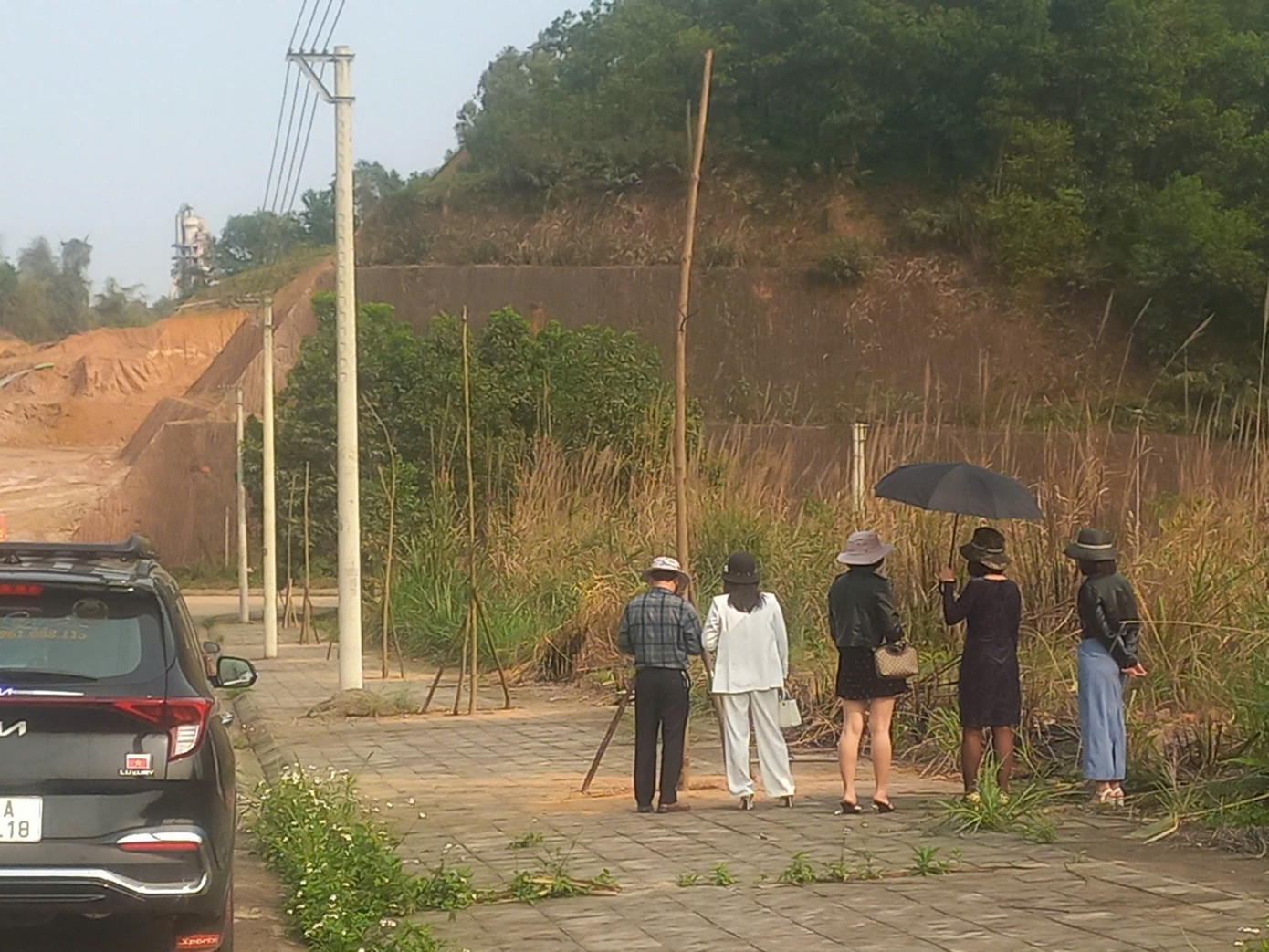 Khách đi xem các lô đất tại khu đô thị cỏ dại mọc cao. Khách đi xem các lô đất tại khu đô thị cỏ dại mọc cao.