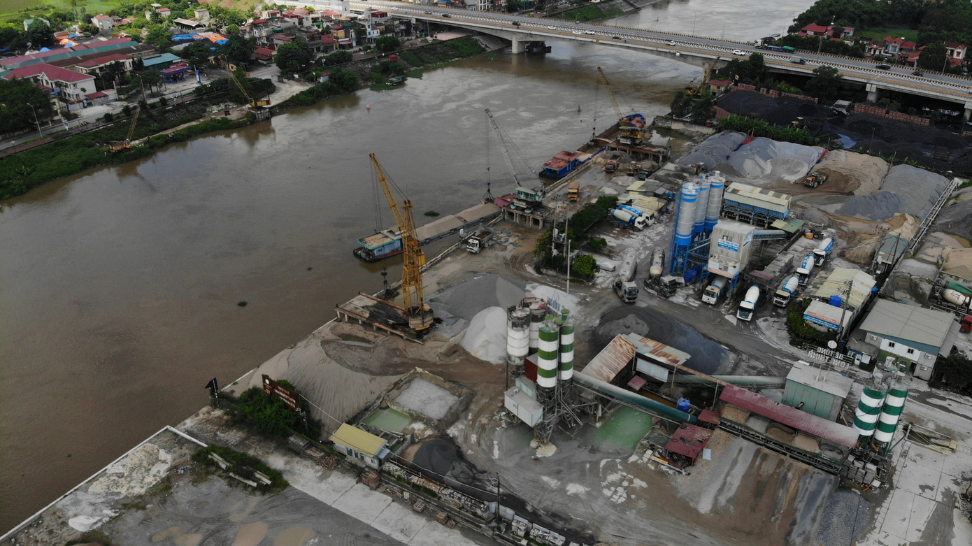 Phía tả ngạn sông Cầu, bến, bãi tập kết cát sỏi, trạm bê tông không phép, hết phép, sai mục đích sử dụng đất... vẫn hoạt động rầm rộ tại phường Quang Châu (thị xã Việt Yên, Bắc Giang) trong mùa lũ.