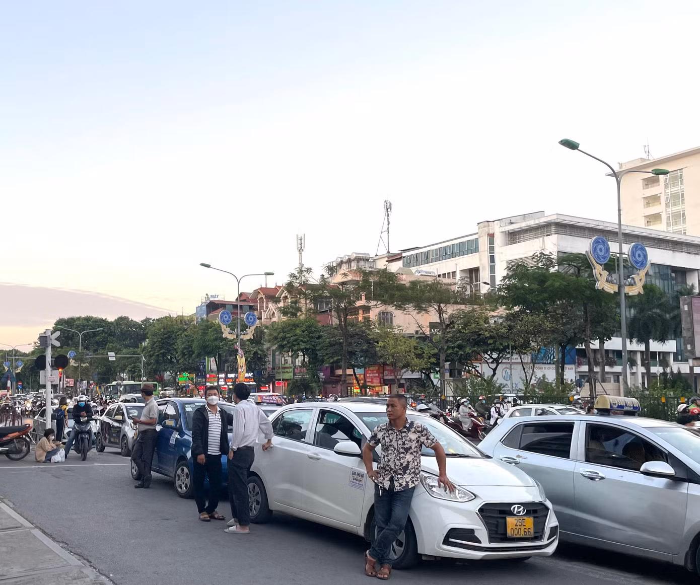 Một cổng khác của bệnh viện Bạch Mai, cũng trên đường Giải Phóng cũng diễn ra tình trạng tương tự. Mặc cho các phương tiện lưu thông trên đường đang tìm lối để di chuyển, cánh lái xe vẫn đỗ xe tràn ra đường, đứng tán gẫu, chờ khách..