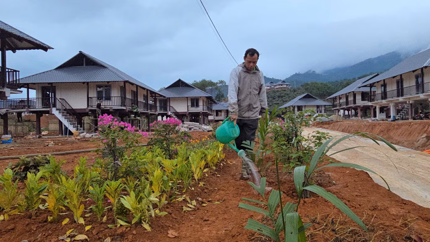 Anh Sầm Văn Bóng tranh thủ sau giờ làm, chăm sóc lại vườn hoa trước căn nhà mới. Trong trận lũ đầu tháng 9 vừa qua, anh Bóng mất đi 5 người thân cùng toàn bộ nhà cửa và tài sản. "Từ khi khu tái định cư bắt đầu xây dựng, cứ có thời gian rảnh là tôi lên đây hỗ trợ, vừa để khuây khỏa, vừa ngắm nhìn bản tương lai", anh Bóng chia sẻ.
