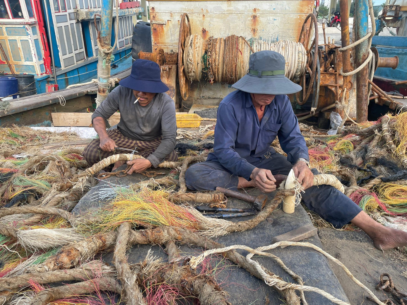 Ông Hùng (thuyền viên một tàu cá tại cảng Thọ Quang) nói: "Mỗi đợt tàu của tôi ra khơi thường khoảng từ 10 ngày đến một tháng, phụ thuộc vào tàu buôn cá. Nếu có tàu ra khơi lấy thủy sản, chúng tôi thường neo đậu đến cả tháng mới vào bờ để lấy thêm lương thực vì mỗi lần tàu ra vào bờ, tốn đến cả 2.000 lít dầu". Theo ông Hùng, sau bão, cá thường nhiều hơn so với bình thường nên ông tranh thủ ra khơi sớm.Trong ảnh, hai ngư dân đang gia cố lại dây thừng dùng để kéo lưới để sẵn sàng ra khơi. Ông Hùng (thuyền viên một tàu cá tại cảng Thọ Quang) nói: "Mỗi đợt tàu của tôi ra khơi thường khoảng từ 10 ngày đến một tháng, phụ thuộc vào tàu buôn cá. Nếu có tàu ra khơi lấy thủy sản, chúng tôi thường neo đậu đến cả tháng mới vào bờ để lấy thêm lương thực vì mỗi lần tàu ra vào bờ, tốn đến cả 2.000 lít dầu". Theo ông Hùng, sau bão, cá thường nhiều hơn so với bình thường nên ông tranh thủ ra khơi sớm.Trong ảnh, hai ngư dân đang gia cố lại dây thừng dùng để kéo lưới để sẵn sàng ra khơi.
