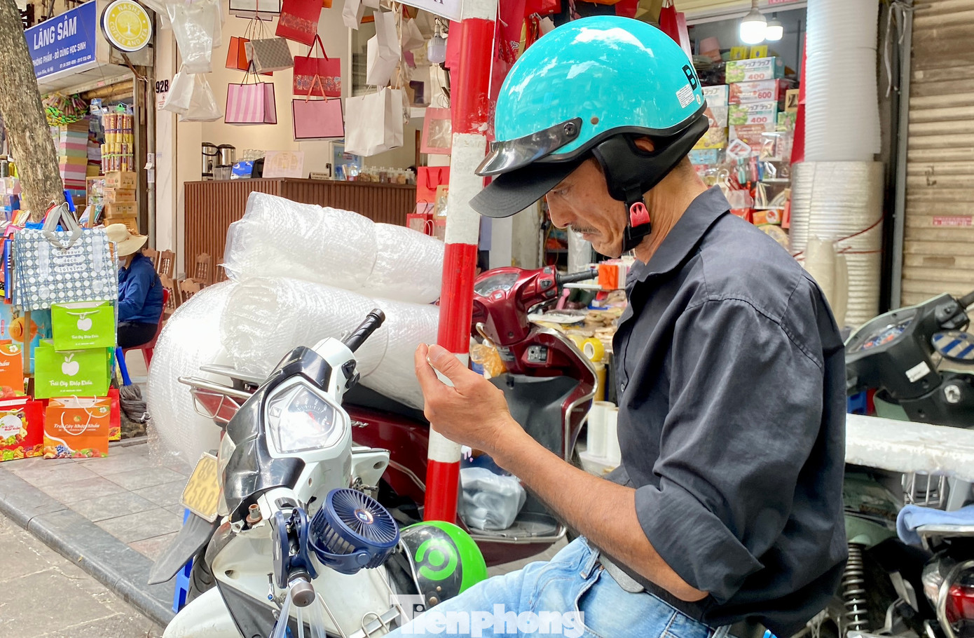 Một số người lao động sử dụng quạt điện mini được gắn ở tay cầm, hoặc dưới thanh sắt để đồ trên xe máy...